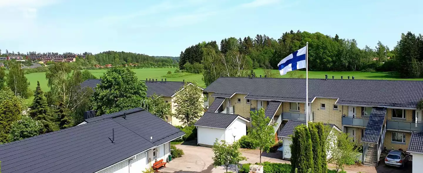 Kaksi mustakattoista rivitaloa ja Suomen lippu salossa