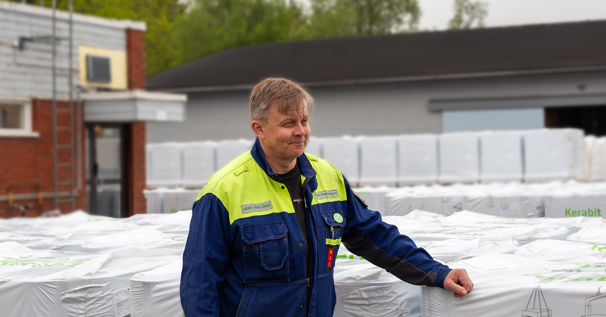 Tuotantopäällikkö Jarmo Hämläinen Lohjan tehtaan pihalla, taustalla bitumikermilavoja