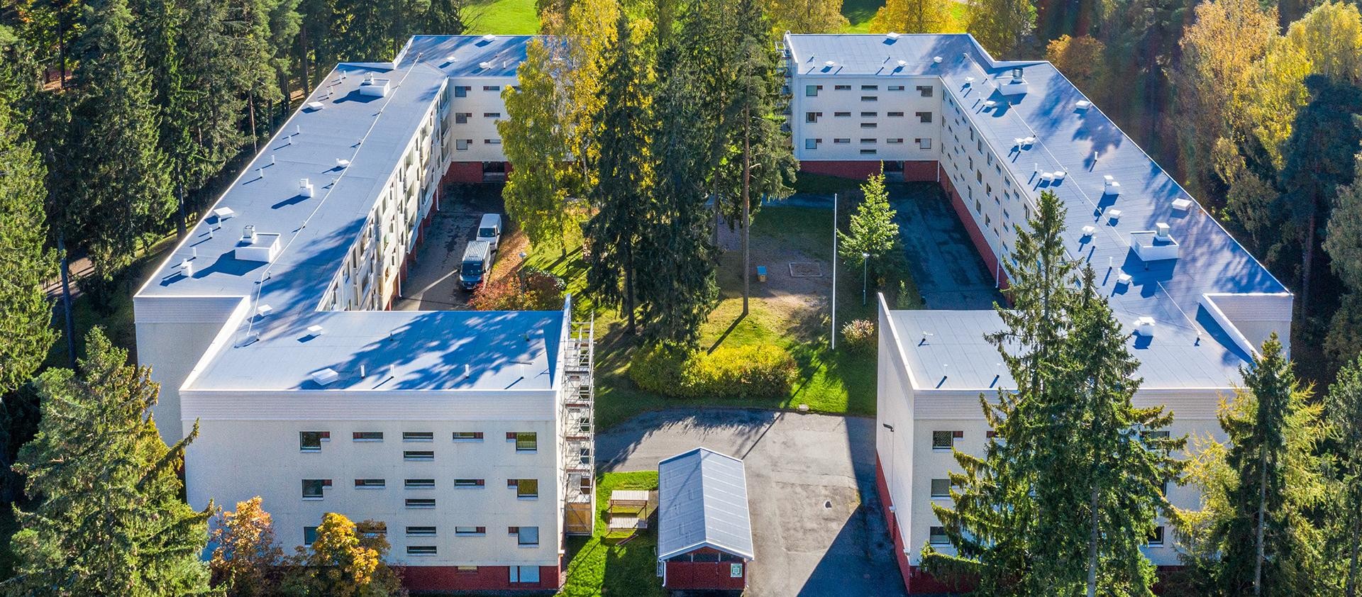 Kaksi kerrostaloa vastakkain, keskellä sisäpiha ja ympärillä puita